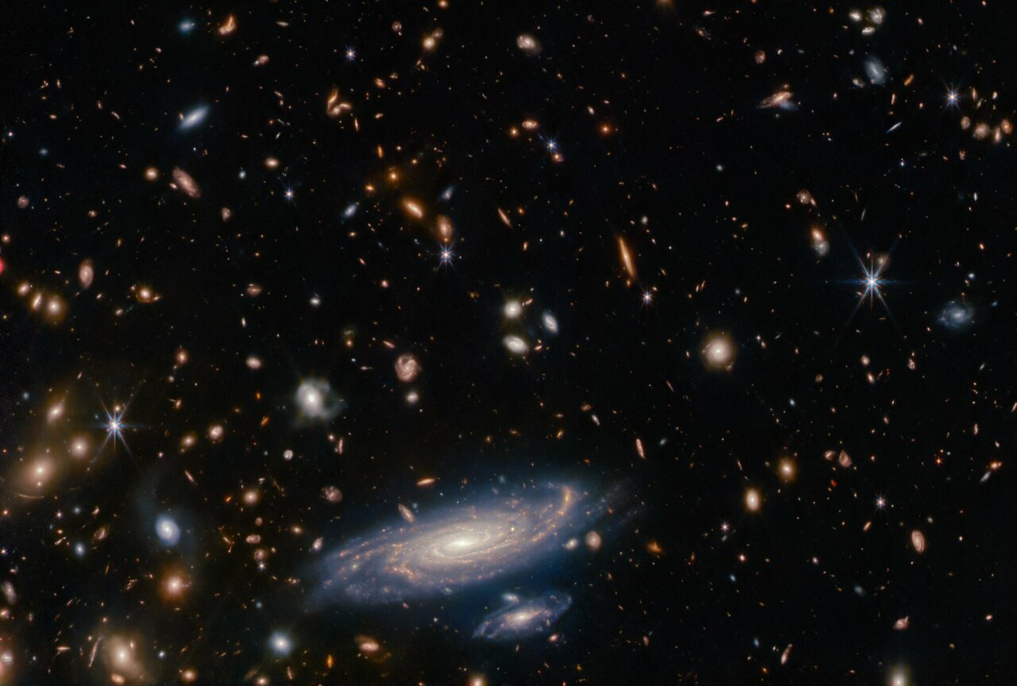 A deep view of the cosmos. LEDA 2046648 is the large galaxy at the bottom.